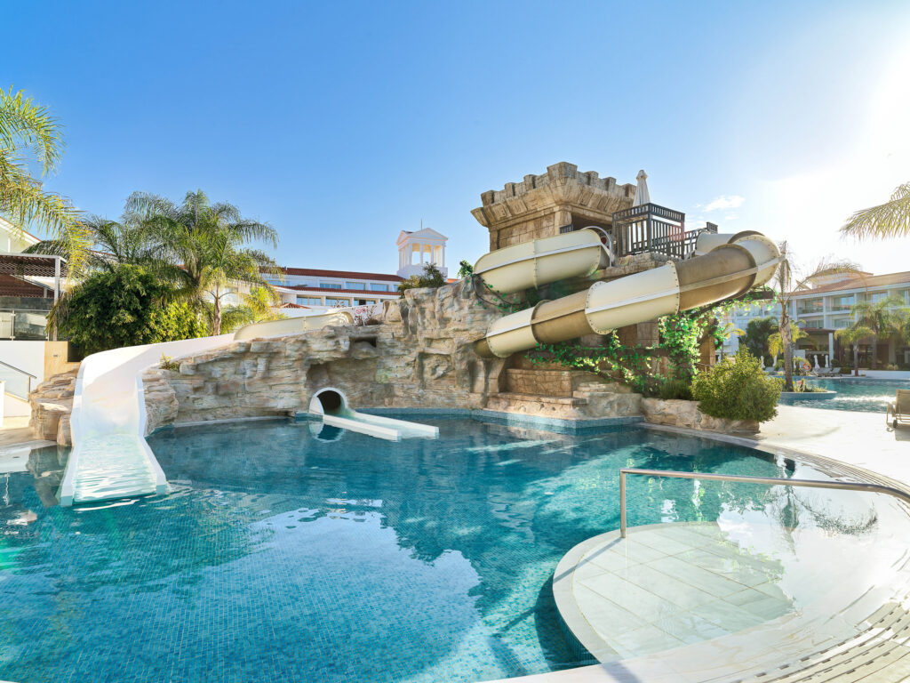 Outdoor pool with water slides at Olympic Lagoon Hotel