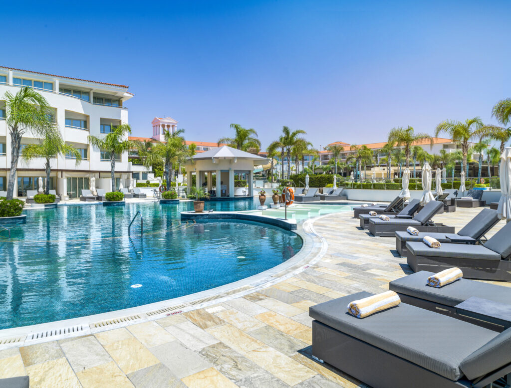 Outdoor pool with loungers at Olympic Lagoon Hotel