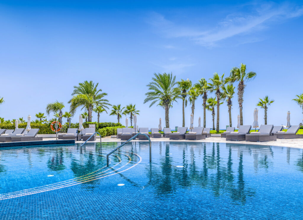 Outdoor pool at Olympic Lagoon Hotel with loungers