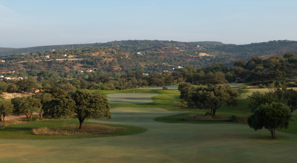 Fairway surrounded by trees and hillsides at Ombria Golf Course