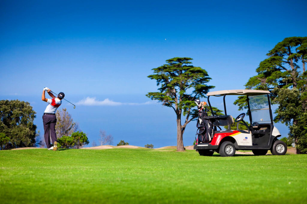 Person playing golf with a buggy at Palheiro Golf Course