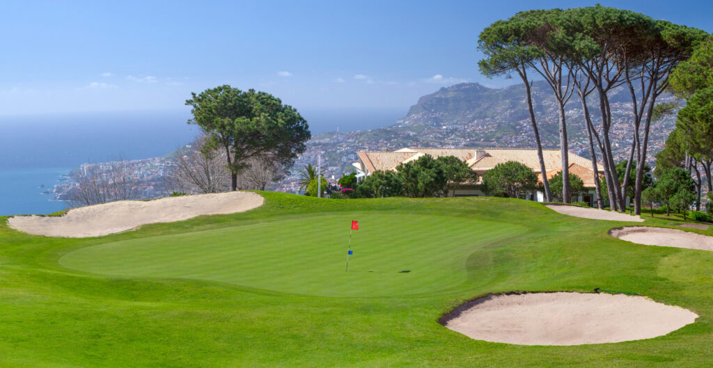 Hole with red flag and bunkers around at Palheiro Golf Course