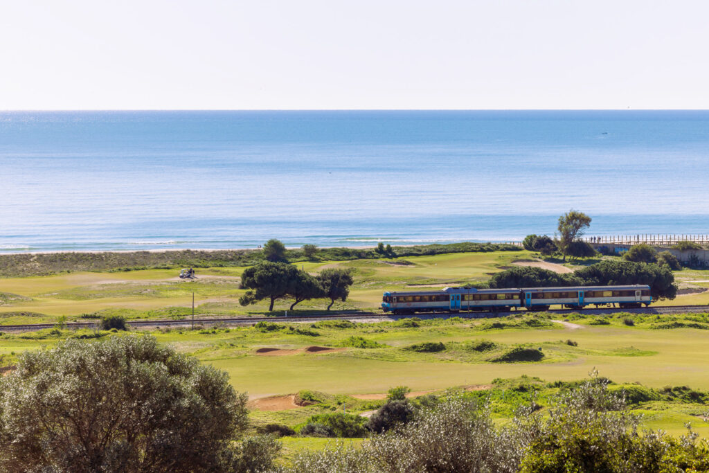 Train passing through Palmares Golf Course with beach view