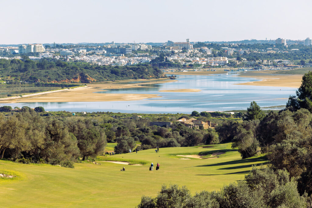 People playing golf at Palmares Golf Course with lake and town in background at Palmares Golf Course