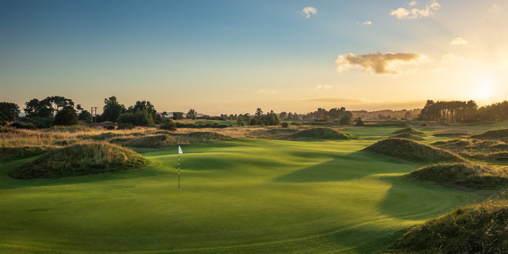 Hole with white flag at Panmure Golf Club with trees around