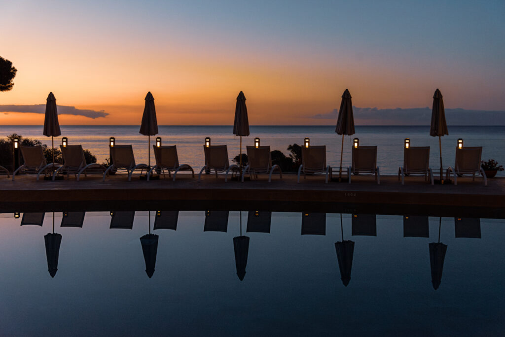 Outdoor pool with loungers at Park Hotel San Jorge at sunset