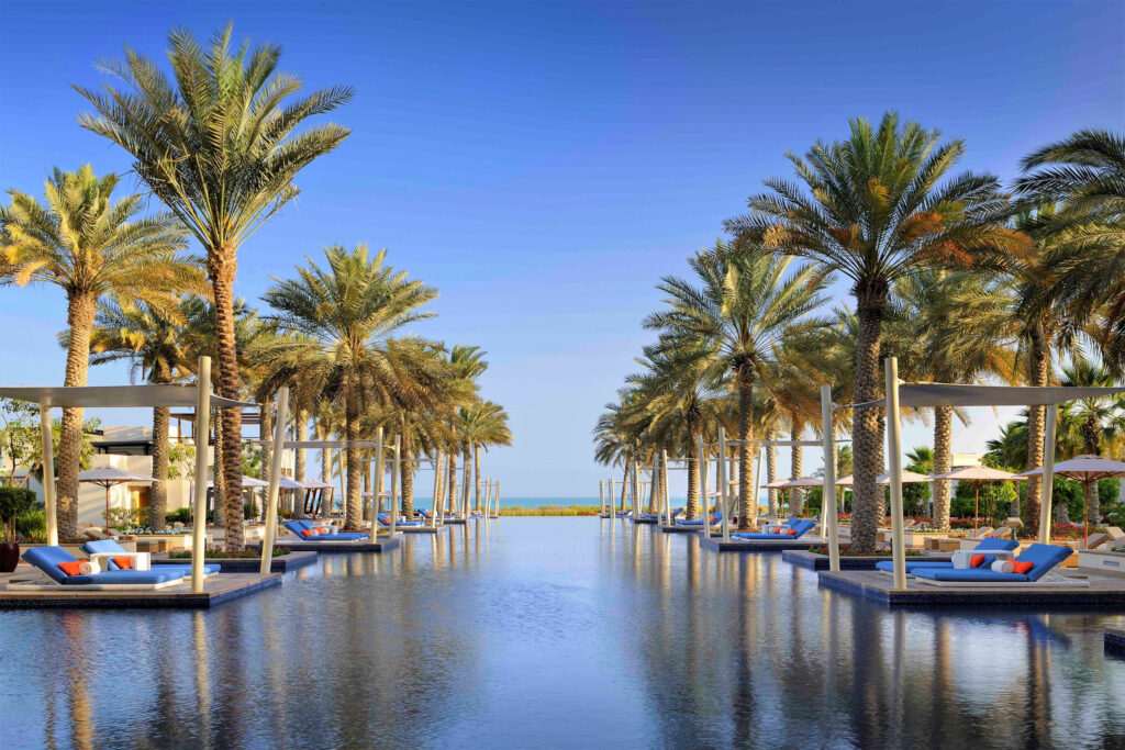 Outdoor pool at Park Hyatt Abu Dhabi with loungers and palm trees