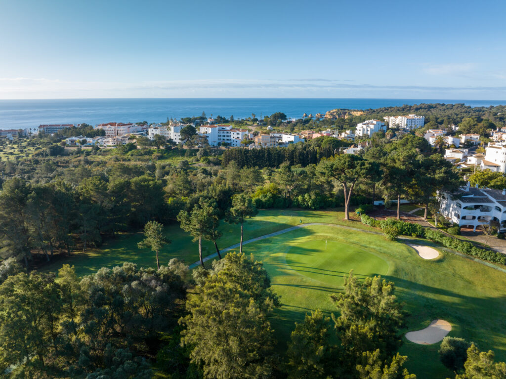 Aerial view of a hole at Alto Golf Course with buildings and ocean in background