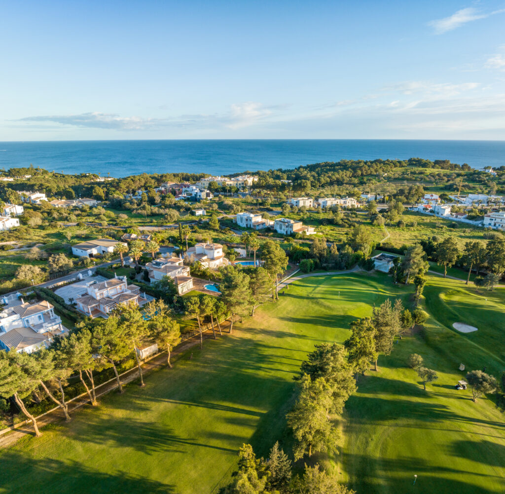 Aerial view of a fairway with ocean and buildings in background at Alto Golf Course