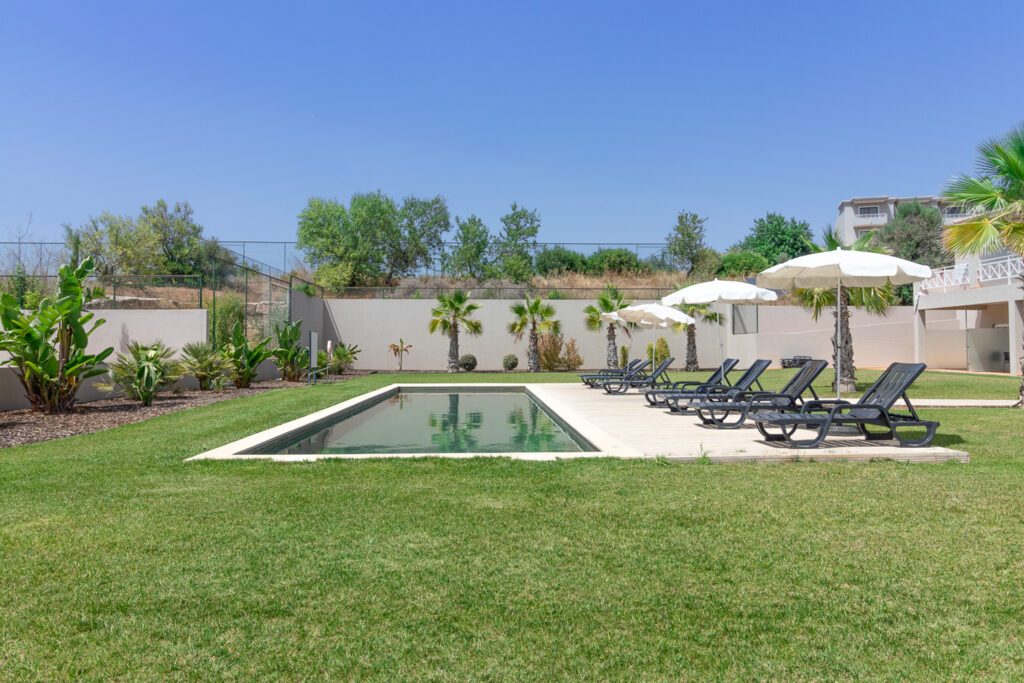Outdoor pool with sun loungsrs at Pestana Gramacho Residences Golf Resort