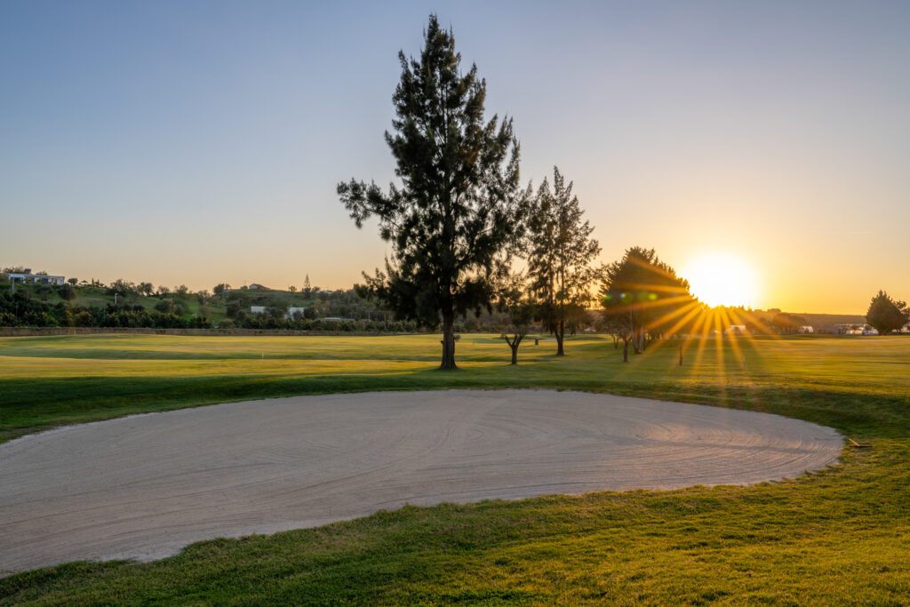 A bunker with trees and sun setting at Silves Golf Course