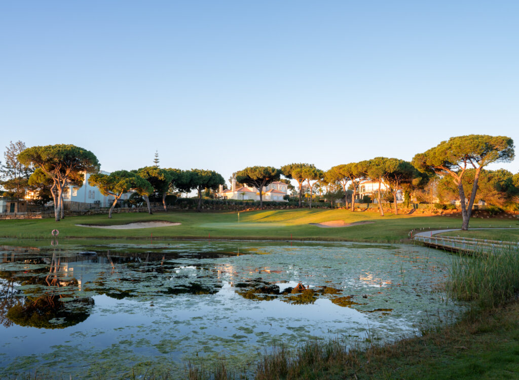 A lake with trees in background at Vila Sol Golf Course