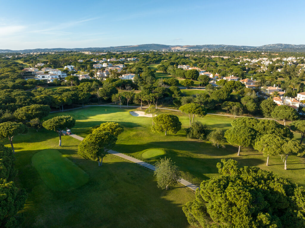 Fairway with a green and bunkers with trees around at Vila Sol Golf Course