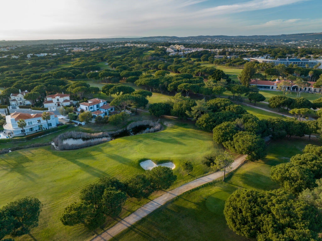 Aerial view of Vila Sol Golf Course with trees and buildings around