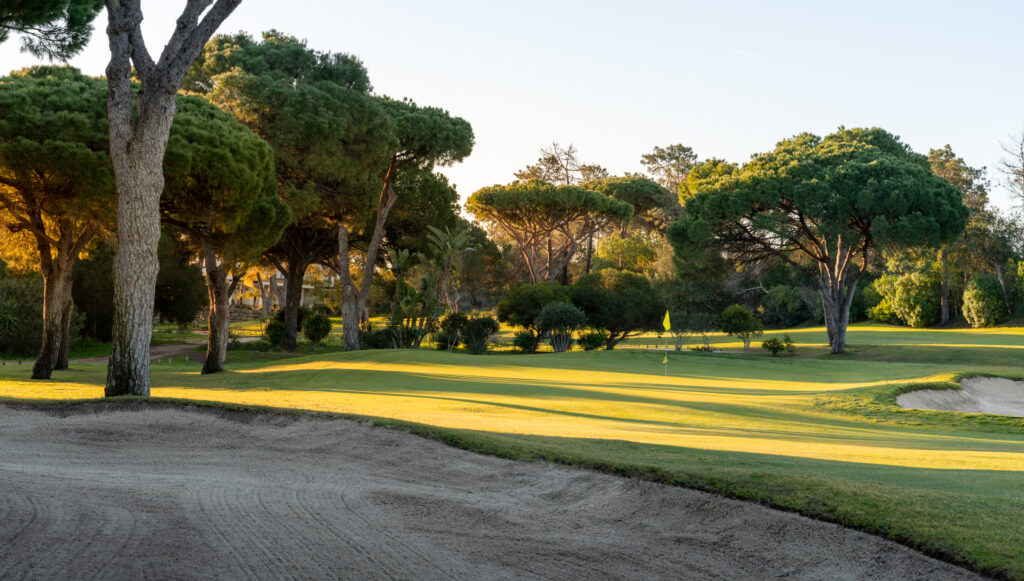 A bunker with a green in background with trees around at Vila Sol Golf Course