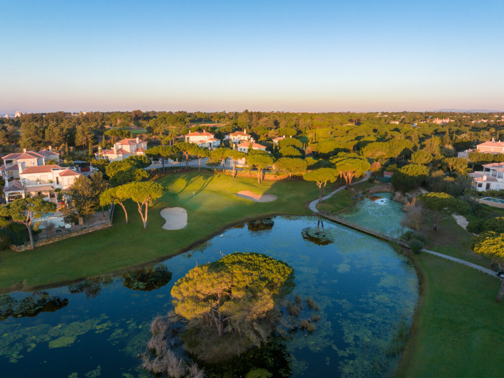 Lake with trees and buildings around at Vila Sol Golf Course