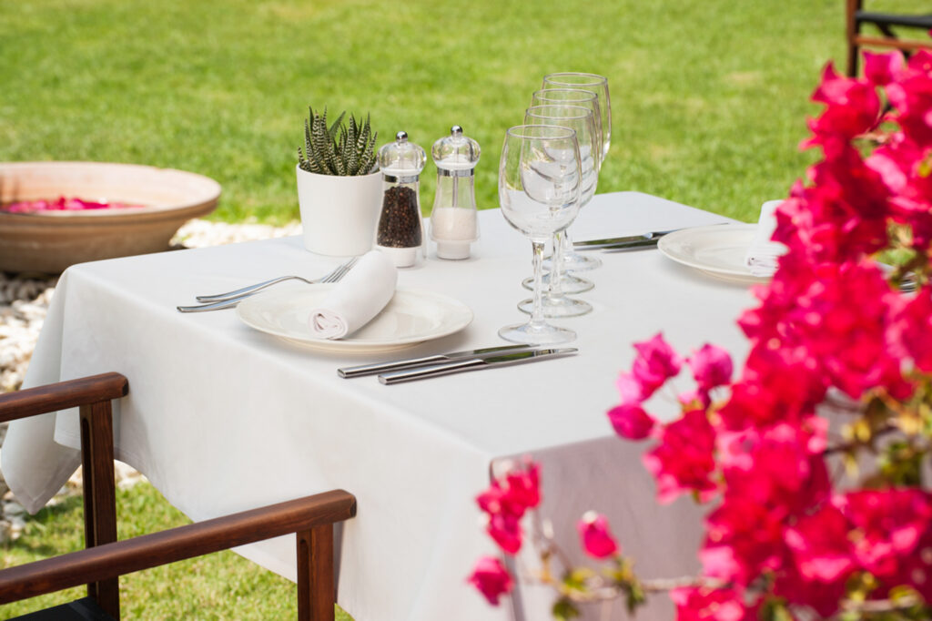 Outdoor dining at Precise Resort El Rompido with pink flowers