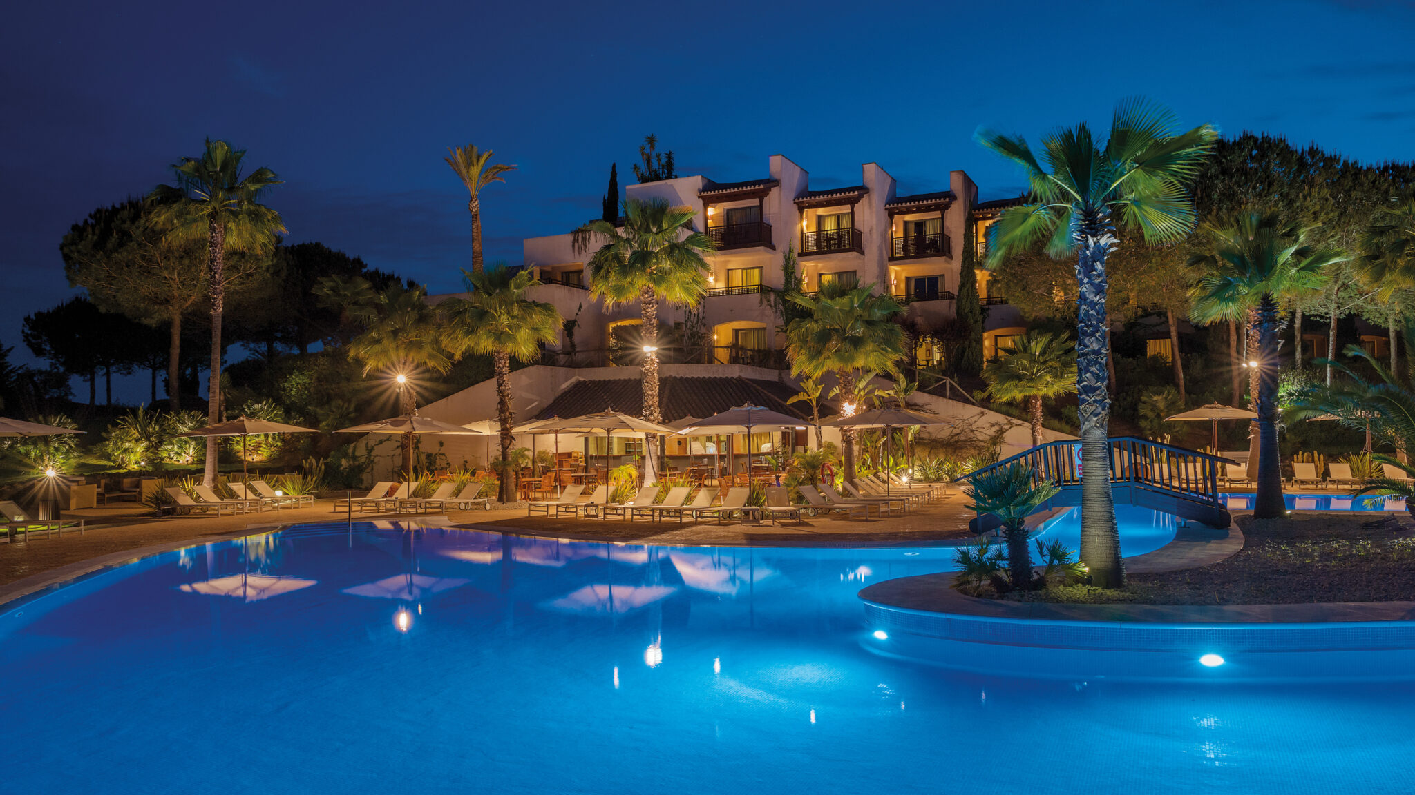 Exterior of Precise Resort El Rompido with outdoor pool and palm trees