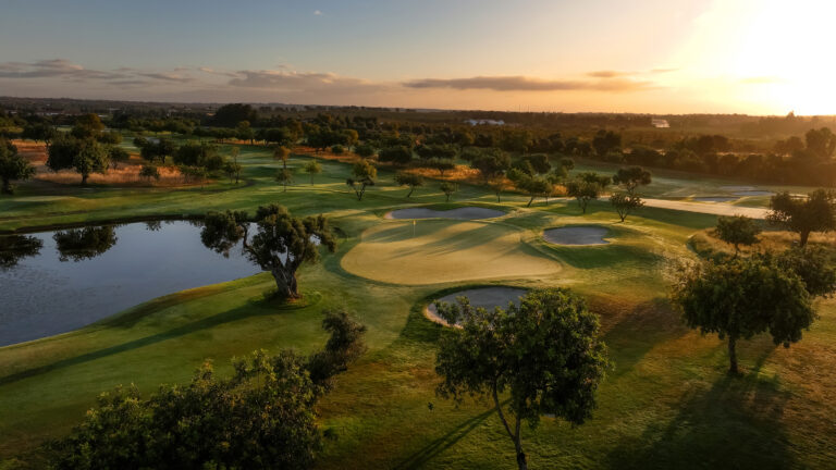 Aerial view of Quinta da Ria Golf Course featuring a green with bunkers and lake next to it