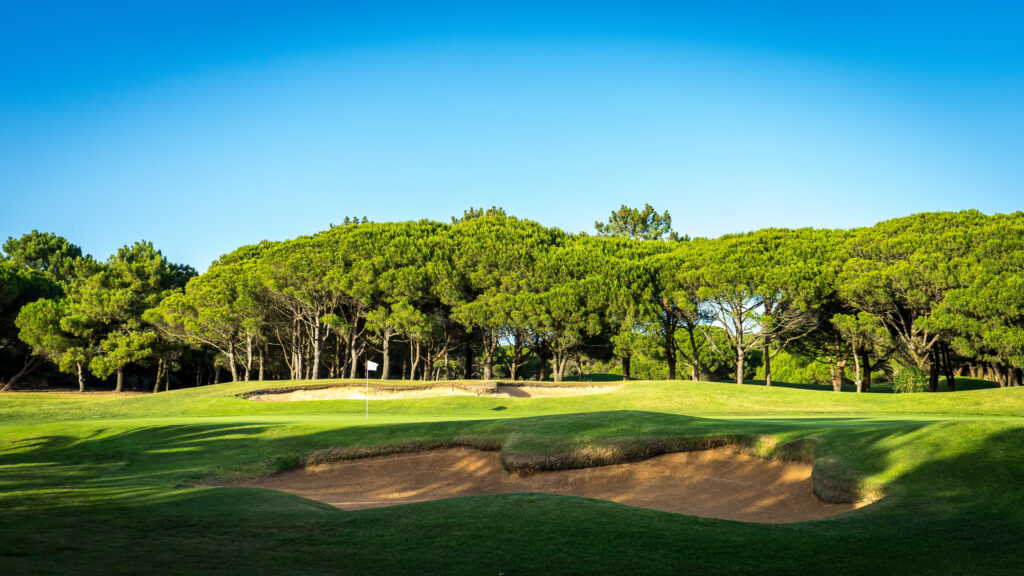 Hole with bunkers and trees in background at Onyria Quinta da Marinha Golf Course