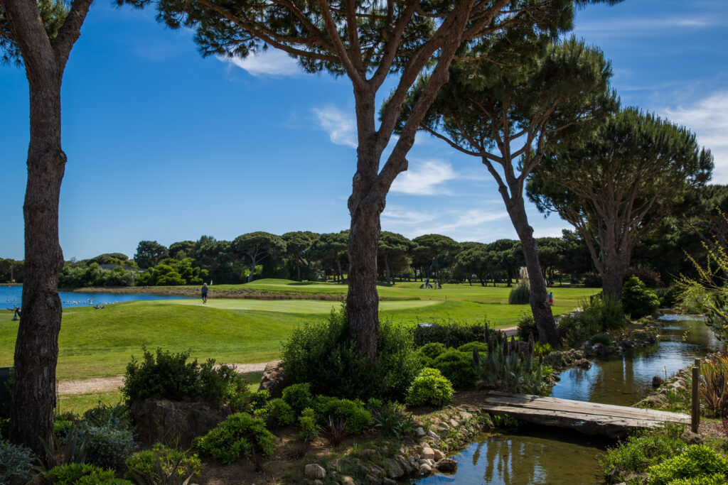 Stream running through fairway with trees lining it at Onyria Quinta da Marinha Golf Course