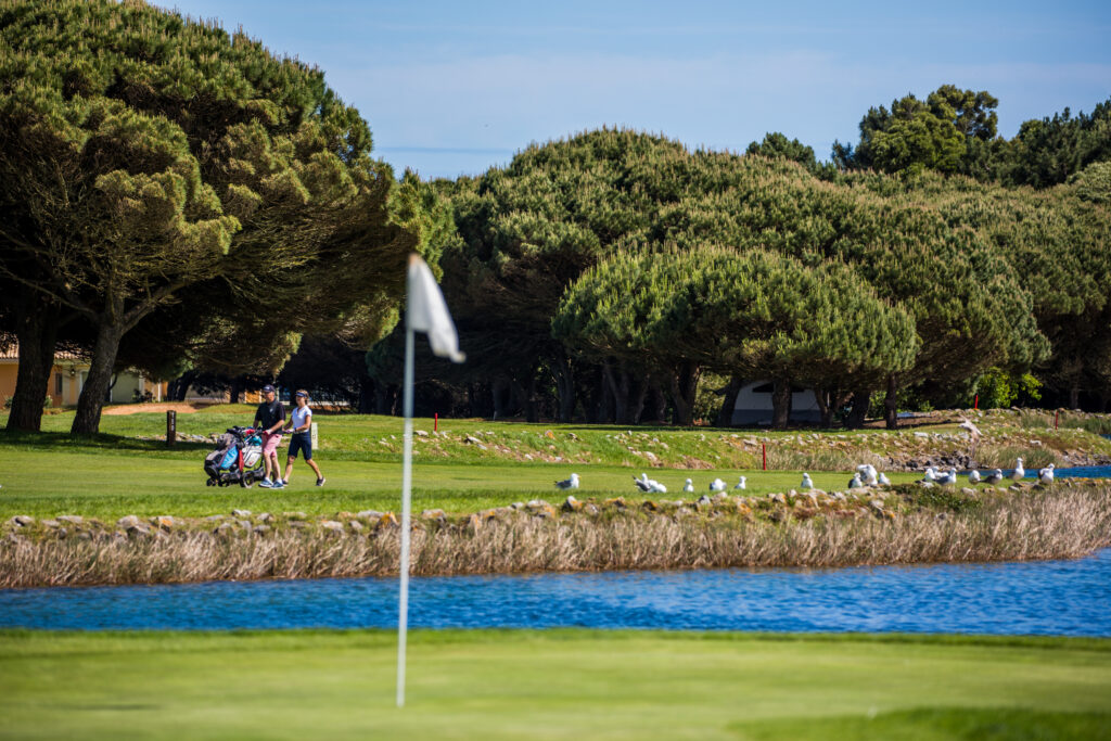 Couple pushing trolleys through the fairway at Onyria Quinta da Marinha Golf Course