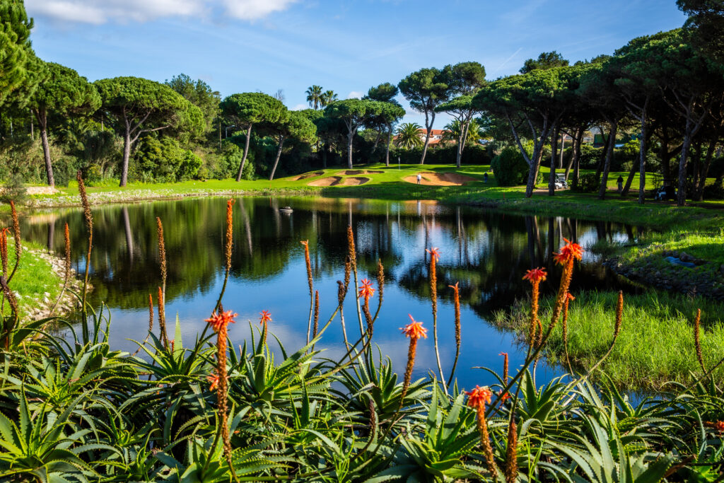 Pond with trees surrounding and bunkers in background at Onyria Quinta da Marinha Golf Course