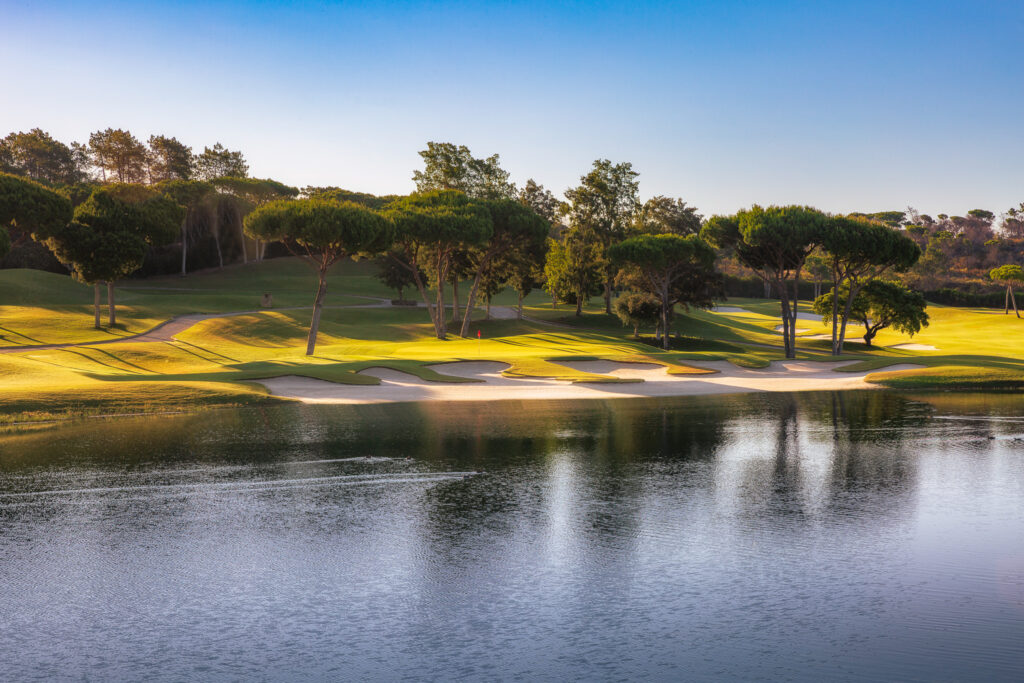 Lake with bunker and trees in background at Quinta Do Lago Laranjal Golf Course