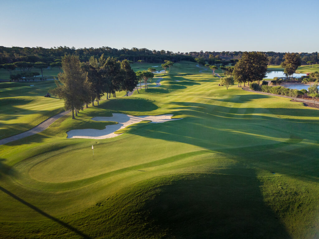 A green with a bunker and trees next to it at Quinta Do Lago Laranjal Golf Course