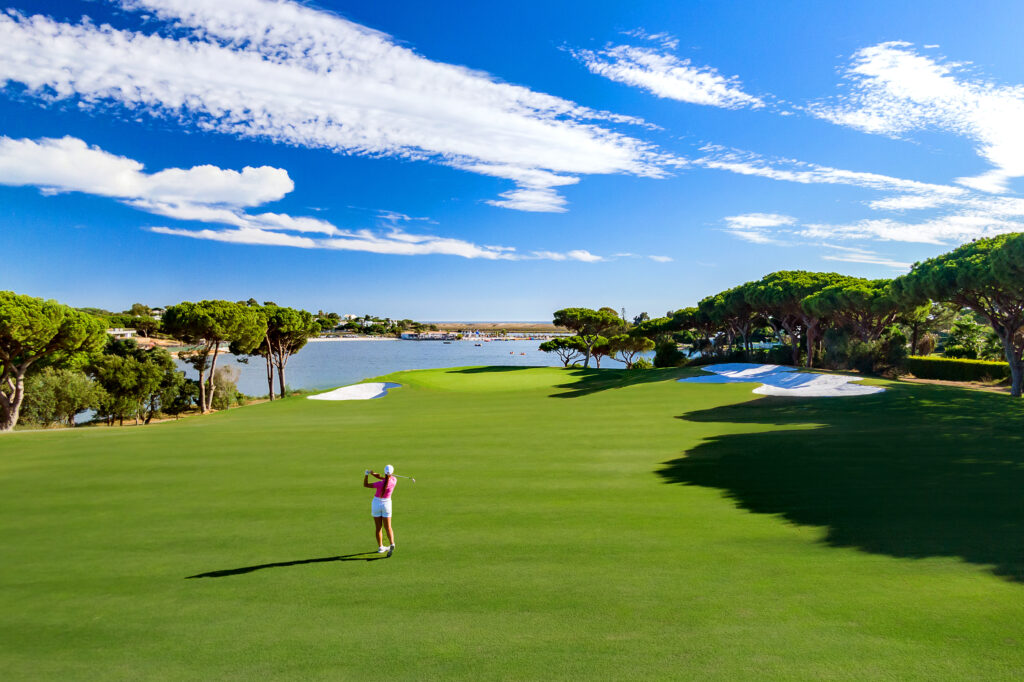 Woman playing golf at Quinta Do Lago South Golf Course with a lake in the background