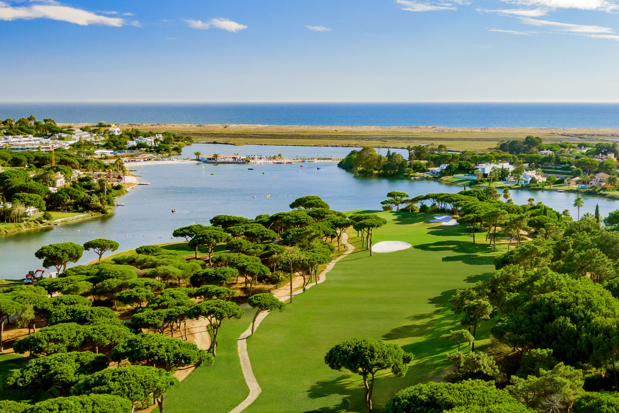 Aerial view of Quinta Do Lago South Golf Course with a lake and beach in background