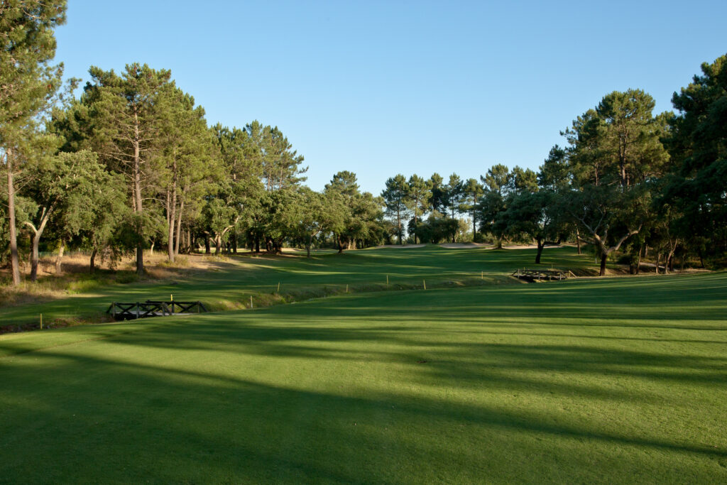 Fairway with bridges going over stream and trees in the background at Quinta do Peru Golf Course