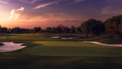 Hole with bunkers and trees around at sunset at Real Club Sevilla Golf