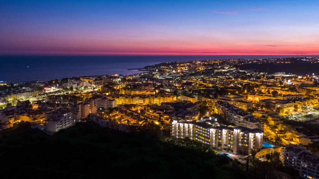 Birdseye of Real Bellavista Hotel and surrounding area at night with a pink sky