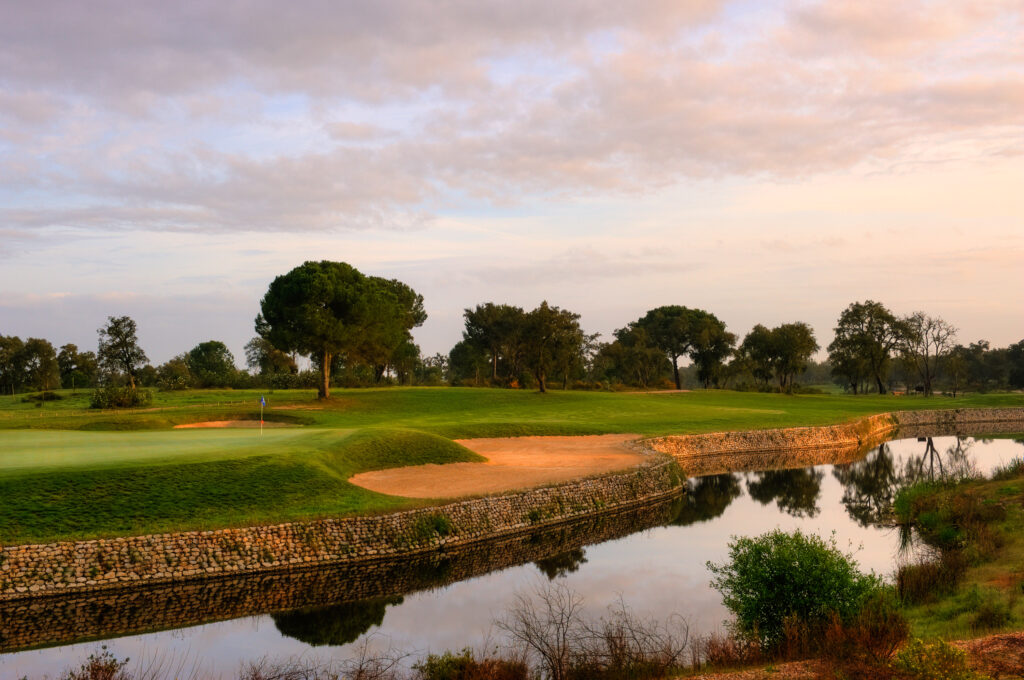 Hole with bunkers and water hazard with trees in the background at Ribagolfe Lakes Golf Course