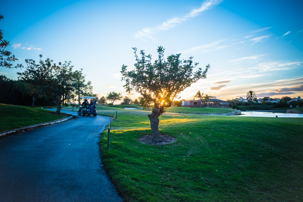 Buggy driving through Roda Golf Course at sunset