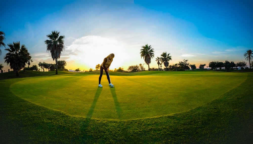 Person playing golf at Roda Golf Course at sunset