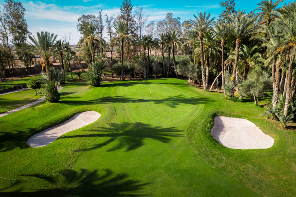 Hole with bunkers at Royal Golf Marrakech with trees around