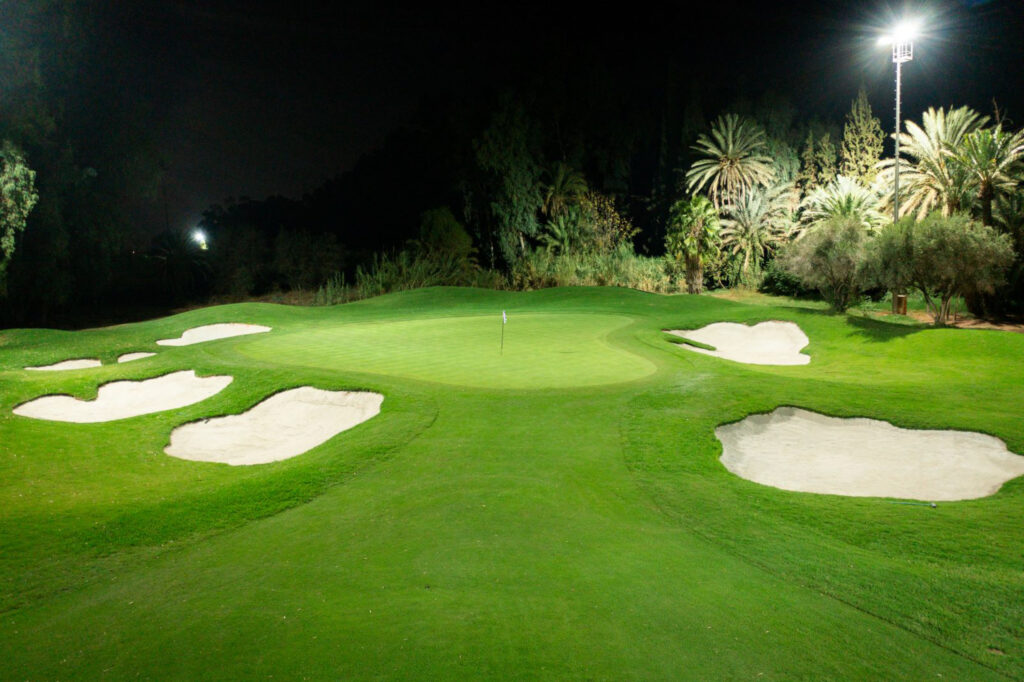 Hole with bunkers and trees around at Royal Golf Marrakech at night