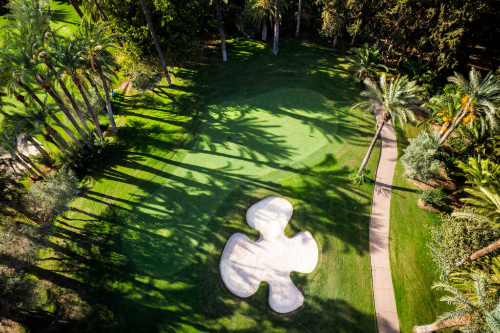 Hole with bunker at Royal Golf Marrakech with trees around