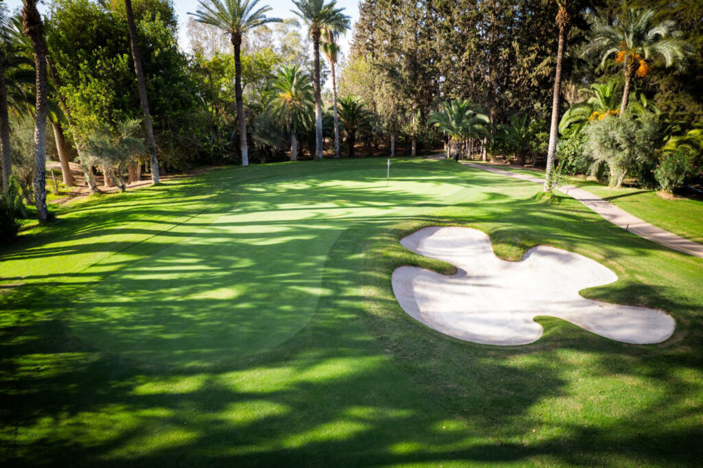 Hole with bunker at Royal Golf Marrakech with trees around