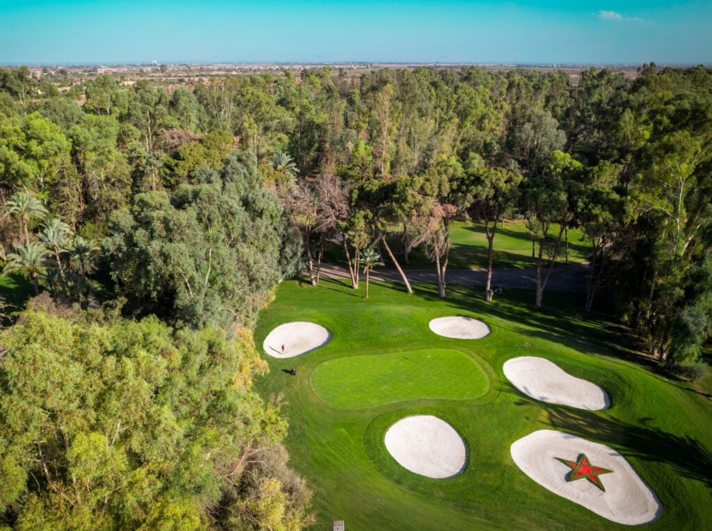 Aerial view of hole with bunkers around at Royal Golf Marrakech with trees around