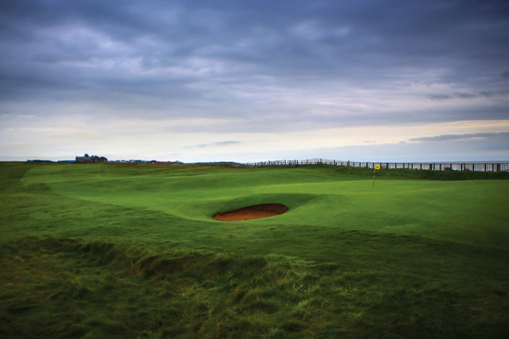 Hole with yellow flag and bunker at Royal Porthcawl