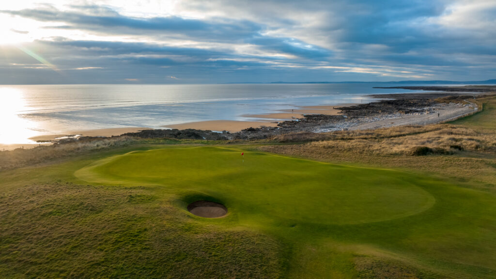 Hole with red flag at Royal Porthcawl next to the beach