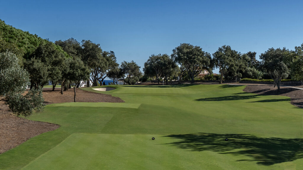 Fairway with trees around and a bunker at San Roque - The Old Course