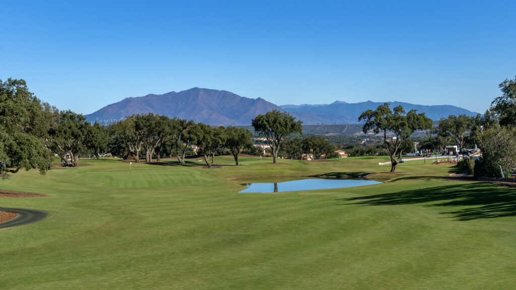 Fairway with water hazard with trees around at San Roque - The Old Course