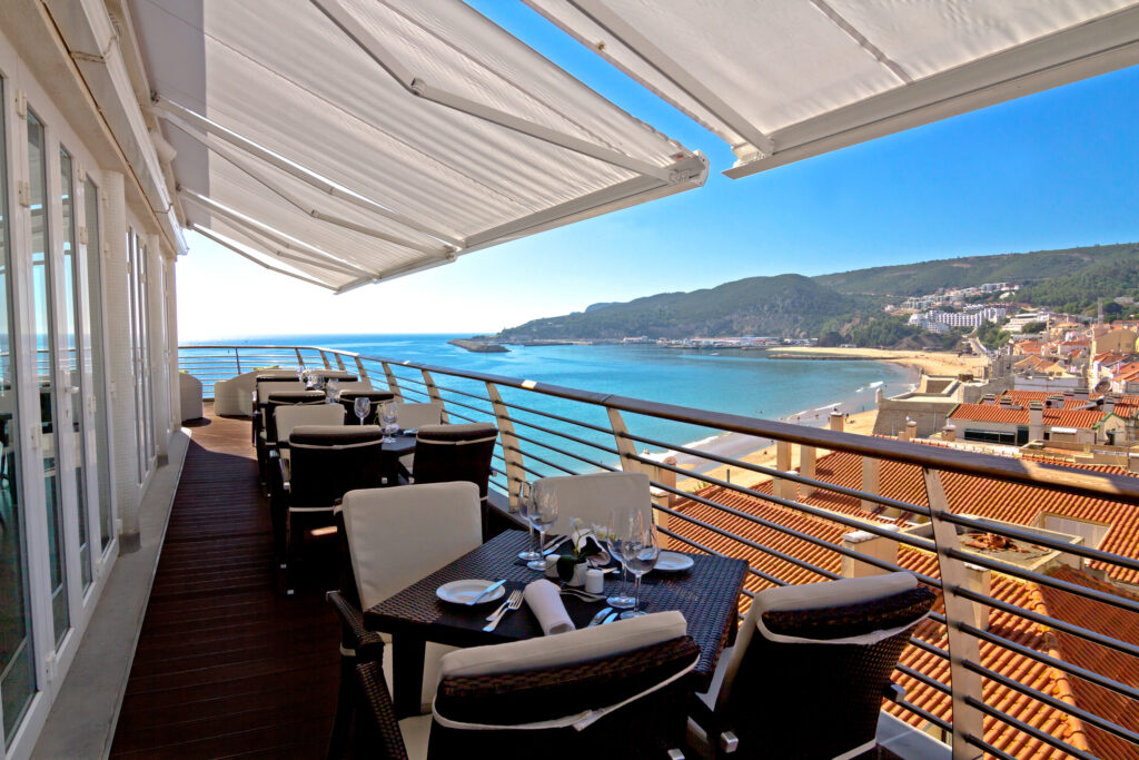 Outdoor dining with beach view at Sana Sesimbra Hotel