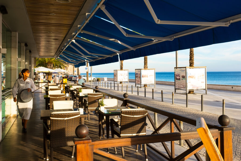 Outdoor dining with a beach view at Sana Sesimbra Hotel