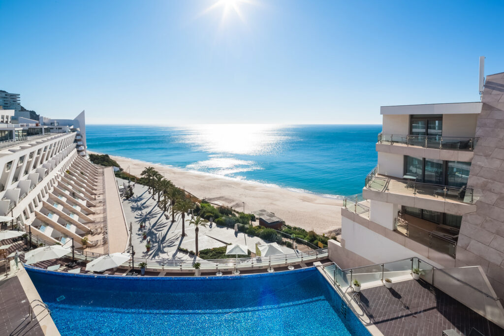 Outdoor pool with beach view at Sesimbra Hotel & Spa