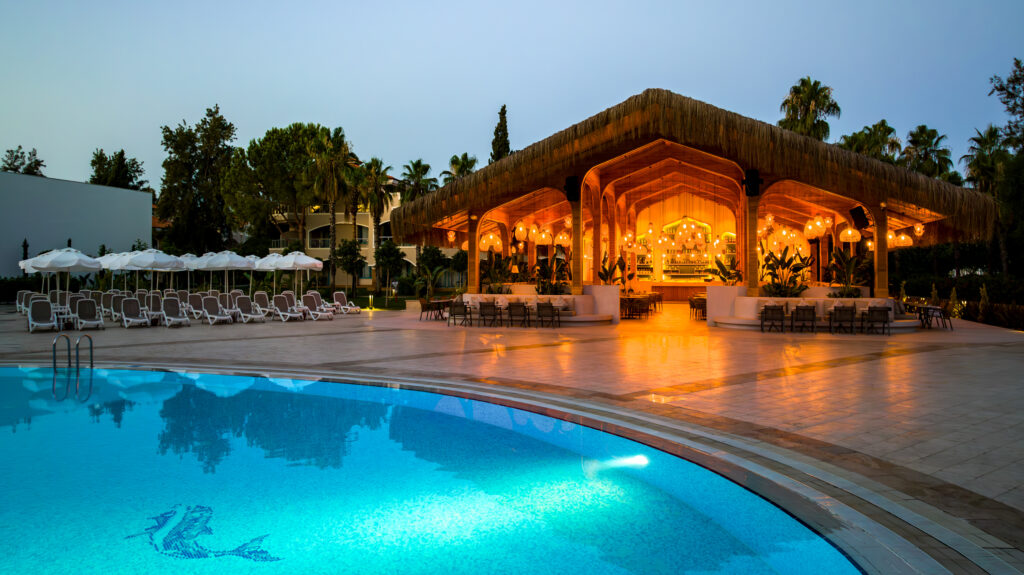 Outdoor pool with loungers and outdoor bar at Sirene Belek Hotel